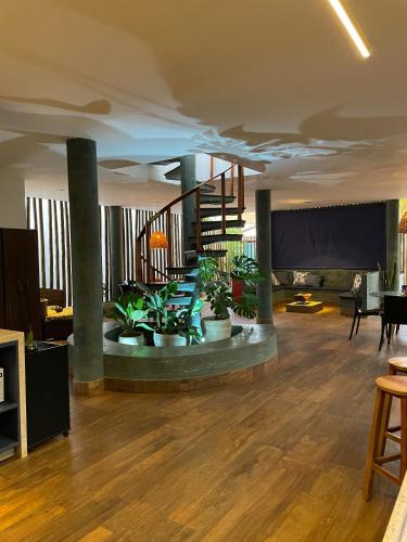 a living room with a spiral staircase and potted plants at Tronco do Ipê Hospedagem in Alto Paraíso de Goiás