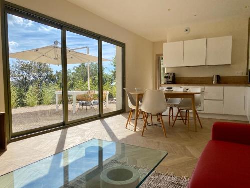 a kitchen and living room with a table and chairs and a glass table at Villa Jacuzzi Calme & Elegance - Prox Mer - Clim & Cheminée - Parking in Cagnes-sur-Mer