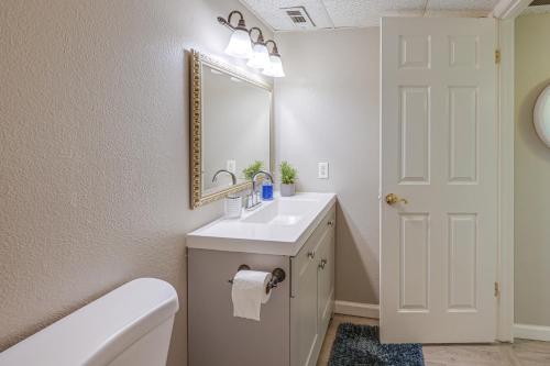 a bathroom with a sink and a mirror and a toilet at Cozy Fresno Condo with Balcony and Pool Access in Fresno