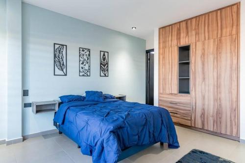 a bedroom with a blue bed and a wooden door at Depa Industrial Moderno y Comodo in Durango