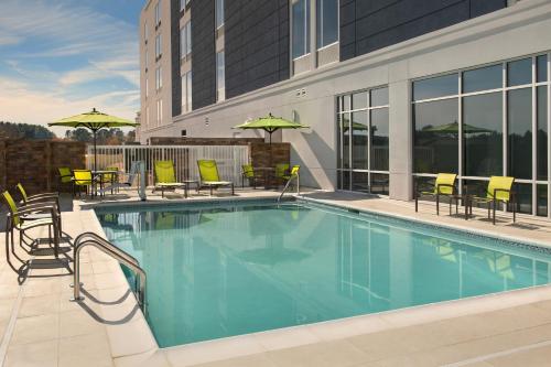 a pool at a hotel with chairs and umbrellas at SpringHill Suites by Marriott Fayetteville I-95 in Fayetteville