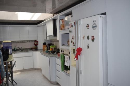 a kitchen with a white refrigerator with magnets on it at Casa Pabón in Bogotá