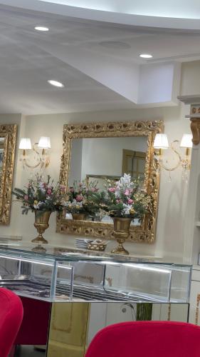 a mirror with two vases of flowers on a counter at Touchlux apartments in Cannes
