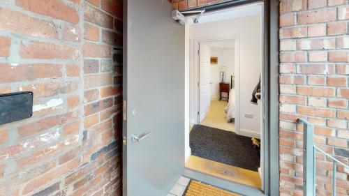 a brick wall with a door leading into a hallway at Ludlow Escapes - Ludlow Town Centre Apartments in Ludlow