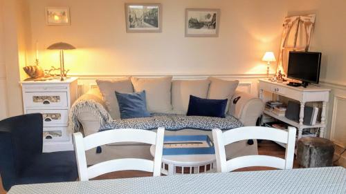 uma sala de estar com um sofá e duas cadeiras em Le Cottage de la Plage - 2ch, 2 SDB - Terrasse - Déco de charme - 500m plage em Cabourg
