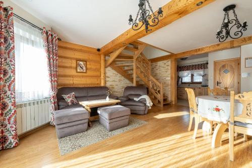 sala de estar con techos de madera, mesa y sillas en Lux-Apart Zakopane, en Zakopane