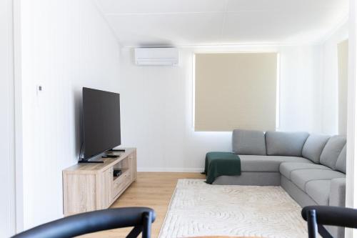 a living room with a couch and a flat screen tv at 40 On North. in Wandoan