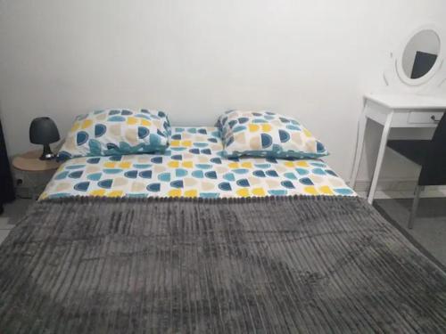 Cette chambre comprend un lit avec deux oreillers et un bureau. dans l'établissement 3 chambres à louer dans l'appartement deux pas à Tramway2, à Colombes