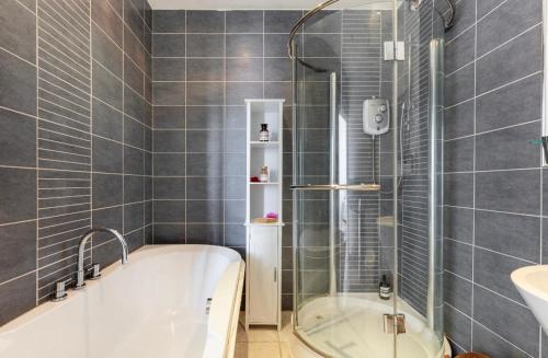 a bathroom with a bath tub and a sink at Loft-style apartment with large roof terrace in London