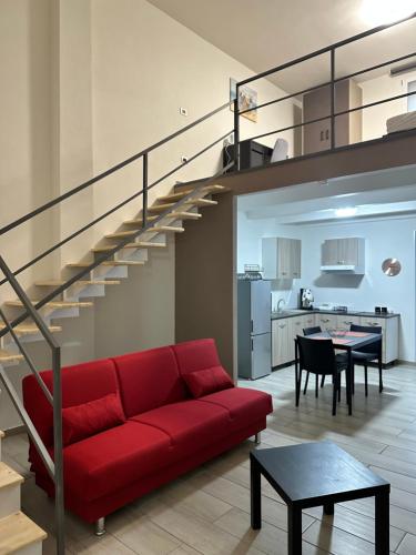 ein Wohnzimmer mit einem roten Sofa und einer Treppe in der Unterkunft Terra Mia Residence in Mugnano di Napoli