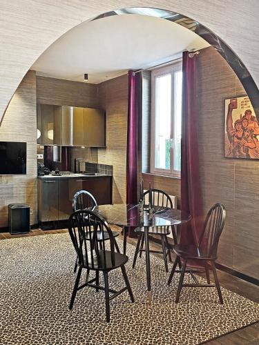 une cuisine et une salle à manger avec une table et des chaises dans l'établissement Les Alcoves - Studios design, à Villers-Cotterêts