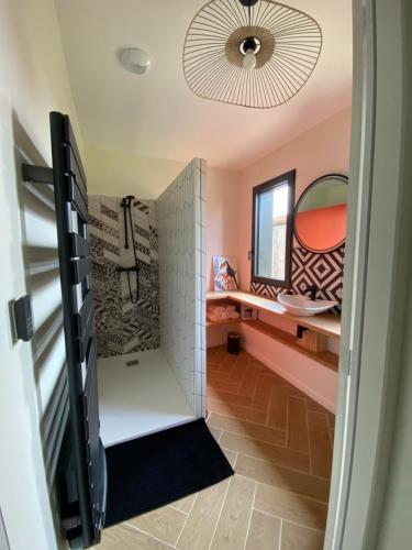 een kamer met een badkamer met een wastafel en een spiegel bij Séchoir rénové, vue panoramique et nombreux jeux in Saint-Pierre-de-Mons