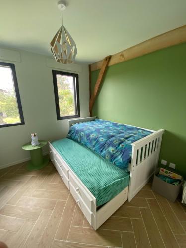 een slaapkamer met een bed met een blauw dekbed bij Séchoir rénové, vue panoramique et nombreux jeux in Saint-Pierre-de-Mons