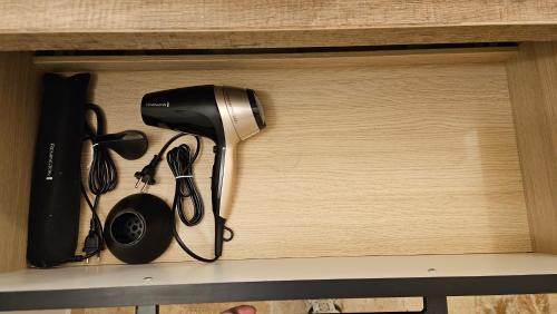 un sèche-cheveux et d'autres ustensiles de cuisine sur une étagère dans l'établissement Studio cosy 32m2 independant dans maison, à La Balme-de-Sillingy