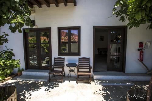two chairs and a table in front of a house at Ambelikos Traditional Agrohotel in Potamitissa