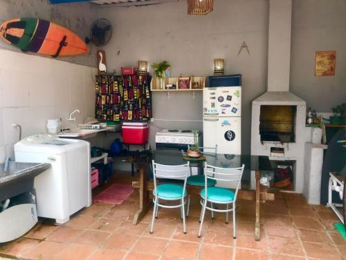 cocina con mesa, sillas y nevera en SURFuncional Guest House en Bertioga