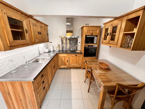 une cuisine avec des armoires en bois et une table en bois dans l'établissement La Mazette, les pieds dans l'eau ! Privatisée ! 16 Pers, à Olargues