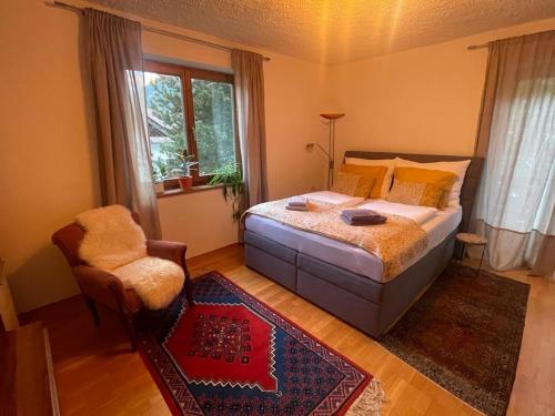 una camera con un letto e una sedia e una finestra di Haus Karin Mallnitz a Mallnitz