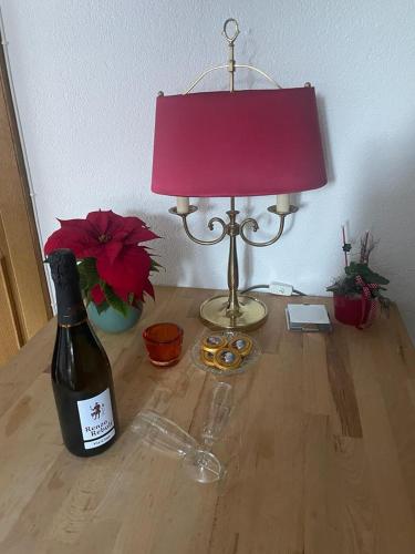 a bottle of wine and a lamp on a wooden table at Haus Karin Mallnitz in Mallnitz