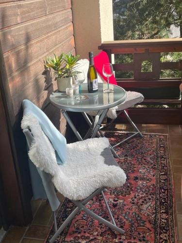 a table with a bottle of wine and two chairs at Haus Karin Mallnitz in Mallnitz
