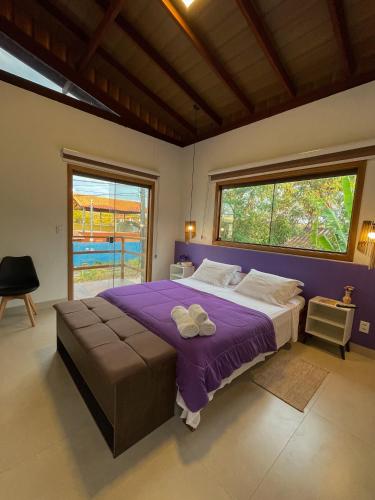 a bedroom with a large bed and a large window at Tronco do Ipê Hospedagem in Alto Paraíso de Goiás