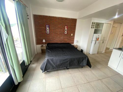 1 dormitorio con cama y pared de ladrillo en el rococosalta en Salta