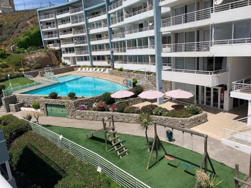 a large apartment building with a pool and a playground at Departamento Vista al mar in Concón