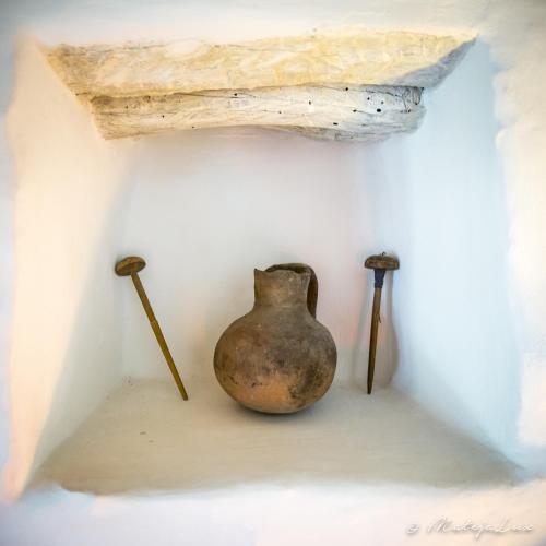 a vase and two swords sitting on a wall at Ambelikos Traditional Agrohotel in Potamitissa