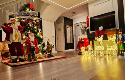 uma sala de Natal com cláusulas do Pai Natal e uma árvore de Natal em Hostal Los Ángeles em Madri