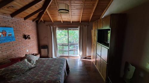 ein Schlafzimmer mit einem Bett, einem Fernseher und einem Fenster in der Unterkunft ATENCIÓN Consultar disponibilidad antes de reservar in Mar de las Pampas