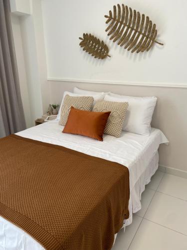 sypialnia z łóżkiem z białą pościelą i poduszkami w obiekcie Flat Sol do Makia - Studio com vista para piscina w mieście Ipojuca