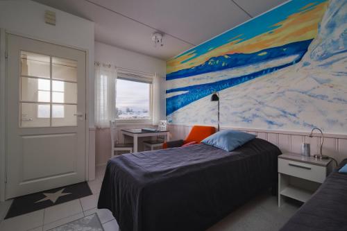 1 dormitorio con 1 cama y una pintura en la pared en Pikkuriikkinen yksiö kaikilla herkuilla Levin keskustassa, en Kittilä