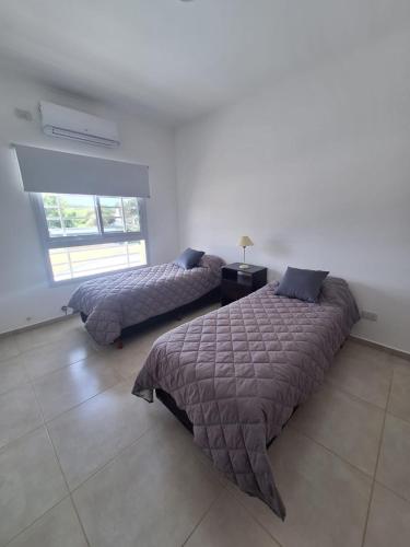 1 Schlafzimmer mit 2 Betten und einem Fenster in der Unterkunft Alberdi 1218 in Colón