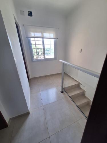 an empty room with a staircase and a window at Alberdi 1218 in Colón