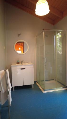 a bathroom with a glass shower and a sink at Bungalow Sobre Águas Camping in Bragança