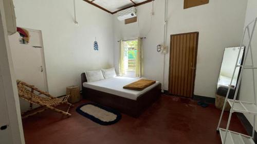 Habitación pequeña con cama y ventana en Assam Villa - by Storyweavers Retreat, en Jorhāt