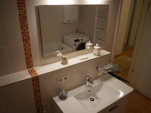 La salle de bains est pourvue d'un lavabo et d'un grand miroir. dans l'établissement Luxus Suite an der Frauenkirche, à Dresde