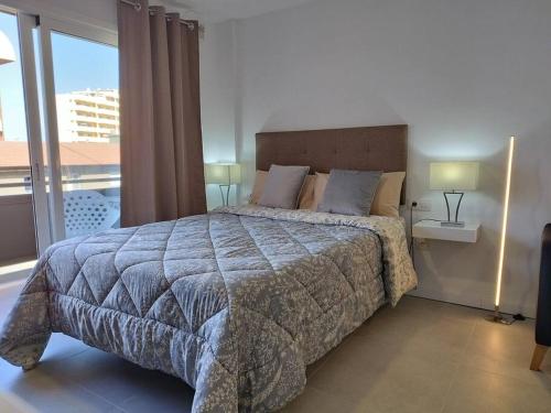 a bedroom with a large bed and a large window at Estudio Playa Jardín in Puerto de la Cruz