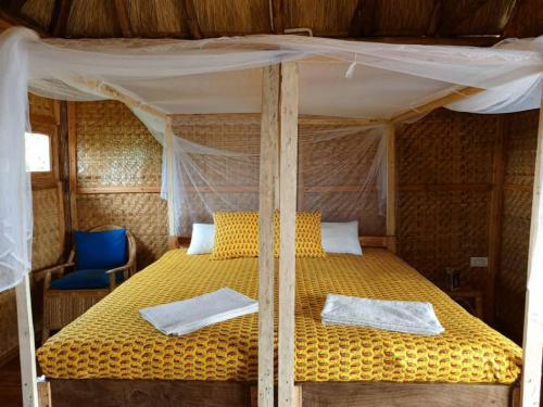 a bed with two pillows on it in a room at Mwamba Kelele Lodge in Fort Portal