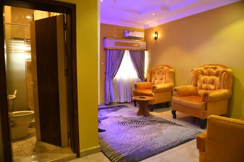 a bathroom with two chairs and a toilet at Portland Resort Hotel in Port Harcourt