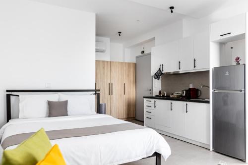 een slaapkamer met een groot bed en een keuken bij Pagani Green - Luxury Studio A1 in Kalamata