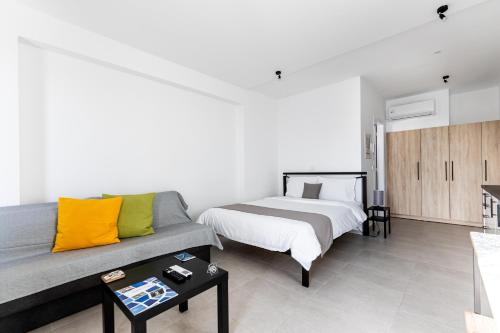 een woonkamer met een bed en een bank bij Pagani Green - Luxury Studio A1 in Kalamata