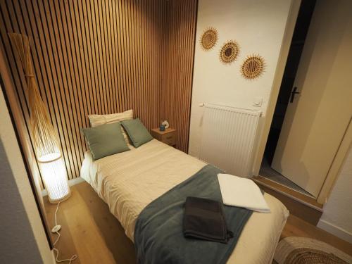 um pequeno quarto com uma cama com um computador portátil em Appartement meublé 4 - 15 min Dampierre - 25 min Belleville - WIFI em Gien