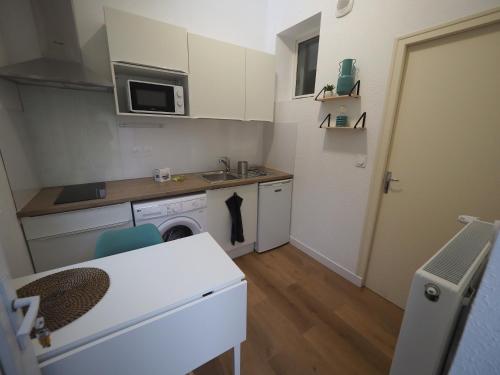 uma pequena cozinha com um lavatório e uma máquina de lavar louça em Appartement meublé 4 - 15 min Dampierre - 25 min Belleville - WIFI em Gien