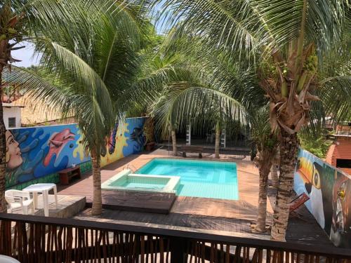 a swimming pool with palm trees on a deck at Pousada Tupaiú in Alter do Chao