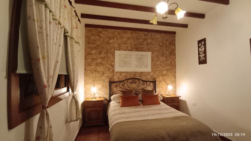 um quarto com uma cama com duas mesas de cabeceira e dois candeeiros em CASA TEJERA II em Las Palmas de Gran Canárias