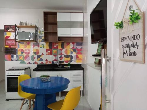 a kitchen with a blue table and yellow chairs at Kitnet Aconchegante em Vitória, B. República in Vitória