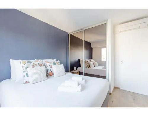 une chambre avec un grand lit blanc avec un miroir dans l'établissement Bright 2 Bed Apt in Cannes, 10 min to Palais, à Cannes