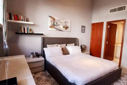 a bedroom with a large bed with white sheets at One Bedroom Apartment (Peaceful & Cozy) in Dubai