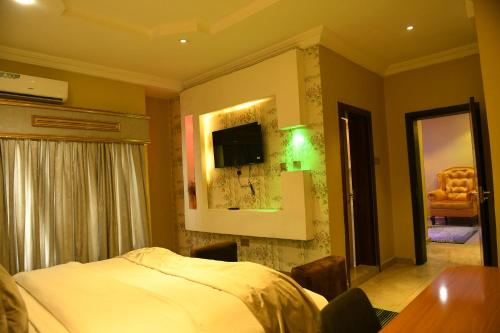 a bedroom with a bed and a tv on the wall at Portland Resort Hotel in Port Harcourt